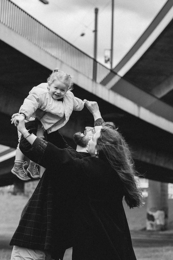 Mama und Papa lassen Tochter hoch fliegen